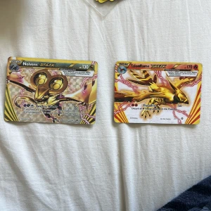 Pokémonkort: Noivern BREAK & Talonflame BREAK - Två Pokémonkort från BREAK-serien: Noivern BREAK och Talonflame BREAK. Båda korten har en guldfärgad, holografisk design med unika illustrationer och specialattacker. Perfekt för samlare eller Pokémon TCG-spelare som vill stärka sin kortlek.