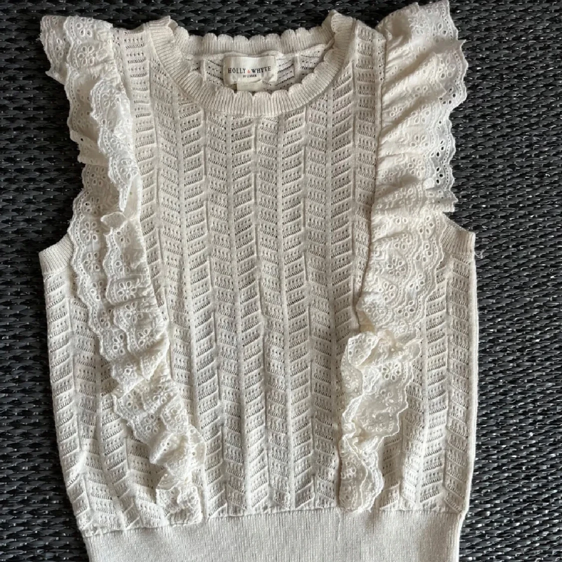 Vit stickad ärmlös topp med volang 