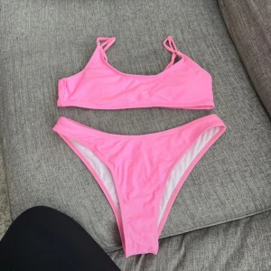Rosa bikini med smala axelband - Säljer en enkel och snygg rosa bikini med smala axelband och klassisk passform. Bikinin har en sportig topp och matchande trosor med hög midja. Perfekt för stranden eller poolen!