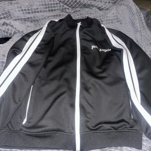 Svart track jacket från Palm Angels - Svart palm angels hoodie storlek M. Är i fint skick, priset kan diskuteras vid snabb affär.