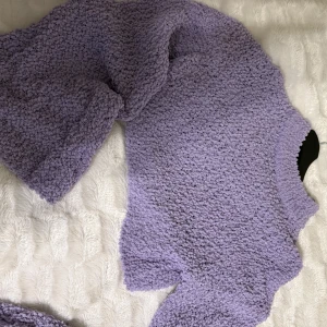 Ljuslila fluffig stickad tröja - Supermjuk och fluffig ljuslila stickad tröja med lång ärm och rund hals. Perfekt för att mysa i under kyliga dagar. Tröjan har en oversized passform och är riktigt gosig.