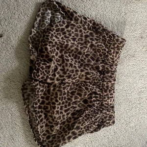 Leopardmönstrade shorts från Name It - Snygga shorts med leopardmönster från Name It. De har elastisk midja och är tillverkade i ett mjukt, lätt material som passar perfekt för varma dagar. Shortsen har en lös passform och är riktigt trendiga.
