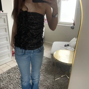 Svart tubtopp med volangdetaljer - Säljer en svart tubtopp med volangdetaljer framtill och diskret mönster. Perfekt som fest topp🥳🥰