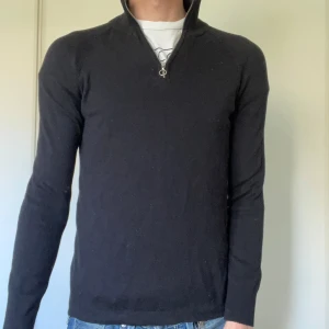 Svart långärmad tröja med dragkedja från H&M - Säljer en svart långärmad tröja från H&M med halv dragkedja vid halsen. Tröjan har en enkel och stilren design, perfekt till jeans eller chinos. Materialet känns mjukt och bekvämt mot huden.