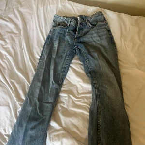 Blå raka jeans från 157 - Säljer ett par klassiska blå jeans från 157 med raka ben och knappgylf. Jeansen har fem fickor och en cool tvättad look som ger en avslappnad vibe. Perfekta för dig som gillar tidlös stil och vill ha ett par jeans som funkar till allt.