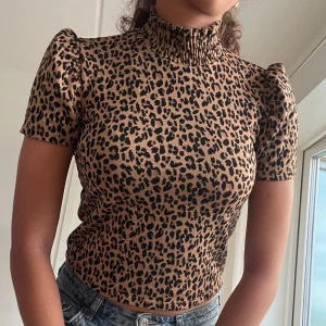Leopardmönstrad topp med puffärm - Snygg croppad topp med leopardmönster från Zara. Hög krage och korta puffärmar.