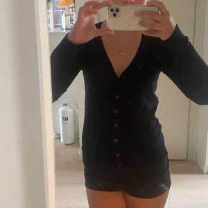 Svart kofta från Polo Ralph Lauren - Svart, klassisk kofta från Polo Ralph Lauren med v-ringning och knappar framtill. Tröjan har lång ärm och är tillverkad i mjuk bomull. Diskret broderad logga på bröstet🤍