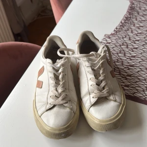 Vita Veja sneakers med rosa detaljer - Använda mycket men nu vill jag sälja mest för att se om nån är intresserad. (Skicka prisförslag) Lite slitningar men inget man märker från långt håll. Säljer ett par klassiska Veja sneakers i vitt skinn med ljusrosa V-logga och häl. Skorna har rund tå, platt sula och snörning.