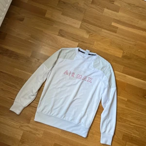 Vit Nike Air Max sweatshirt M, skicka offer/ send offer! - Nike Air Max sweatshirt i vitt med ljusgrå paneler på axlar och ärmar. Framsidan har Air Max-tryck i rött och vitt, och baksidan har en liten röd Nike-logga. Tröjan har rund hals och långa ärmar, tillverkad i mjuk bomull och polyesterblandning. Perfekt för en chill streetwear-look.