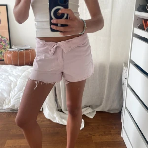 Ljusrosa jeansshorts från H&M Divided - Säljer ett par ljusrosa jeansshorts från H&M Divided i storlek 34. De har fransiga kanter, klassisk femficksdesign och stängs med dragkedja och knapp. Perfekta för varma dagar och har en snygg, avslappnad vibe.