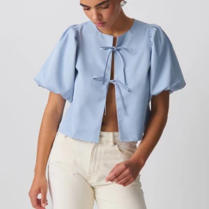 Ljusblå blus med puffärm och knyt -  Bra skick!!.