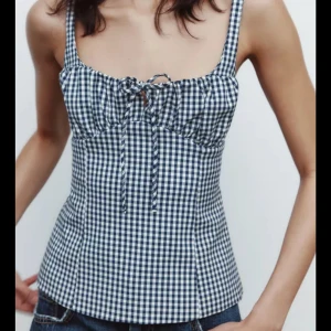 Rutig korsettopp från Zara - Supersnygg korsettopp från Zara i svartvitt rutigt mönster. Toppen har breda axelband, snörning framtill. Sälj då den inte andvänds, priset kan diskuteras vid snabbt köp
