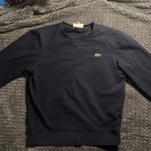 Lacoste sweatshirt - Mörkblå Lacoste tröja. säljs för att den har blivit för lite. Skriv för minsta intresse!