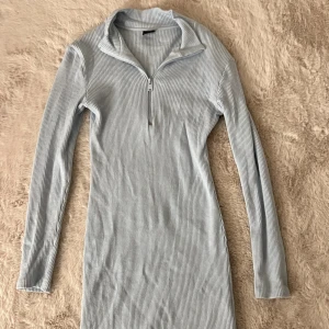 Klänning - En blå stickad klänning. Slutar ovanför knäna