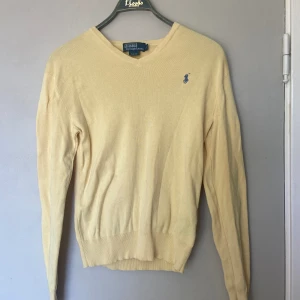 Ralph Lauren tröja - Ljusgul Ralf Lauren tröja med v-krage. Aldrig använd och köpt ny, så kvaliten är toppen! Står att storleken är S men sitter lite löst på mig som är M.