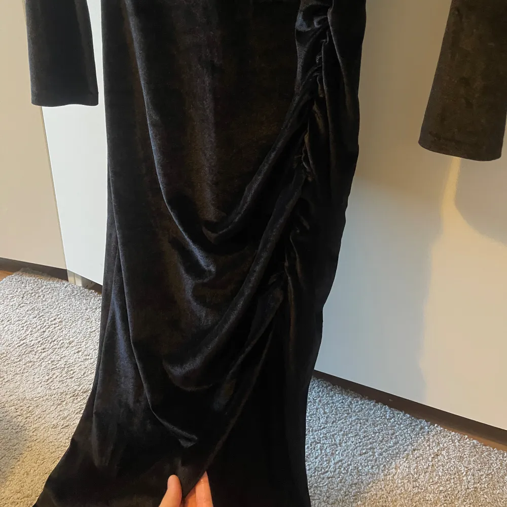 Lång svart klänning i sammet från nellys egna märke, har slits vid sidan och dragkedja bak. använd 1 gång. Klänningar.