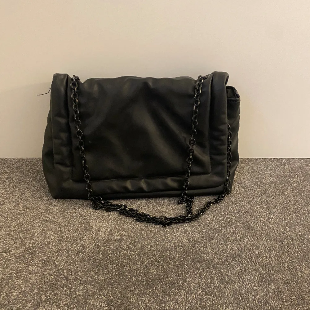 Perfekt svart handväska från HM med en kedja som axelband. Bandet är justerbart så man kan antigen ha väskan som på bilden på axeln eller som crossbody bag! Den är något sliten men ändå bra skick!. Väskor.