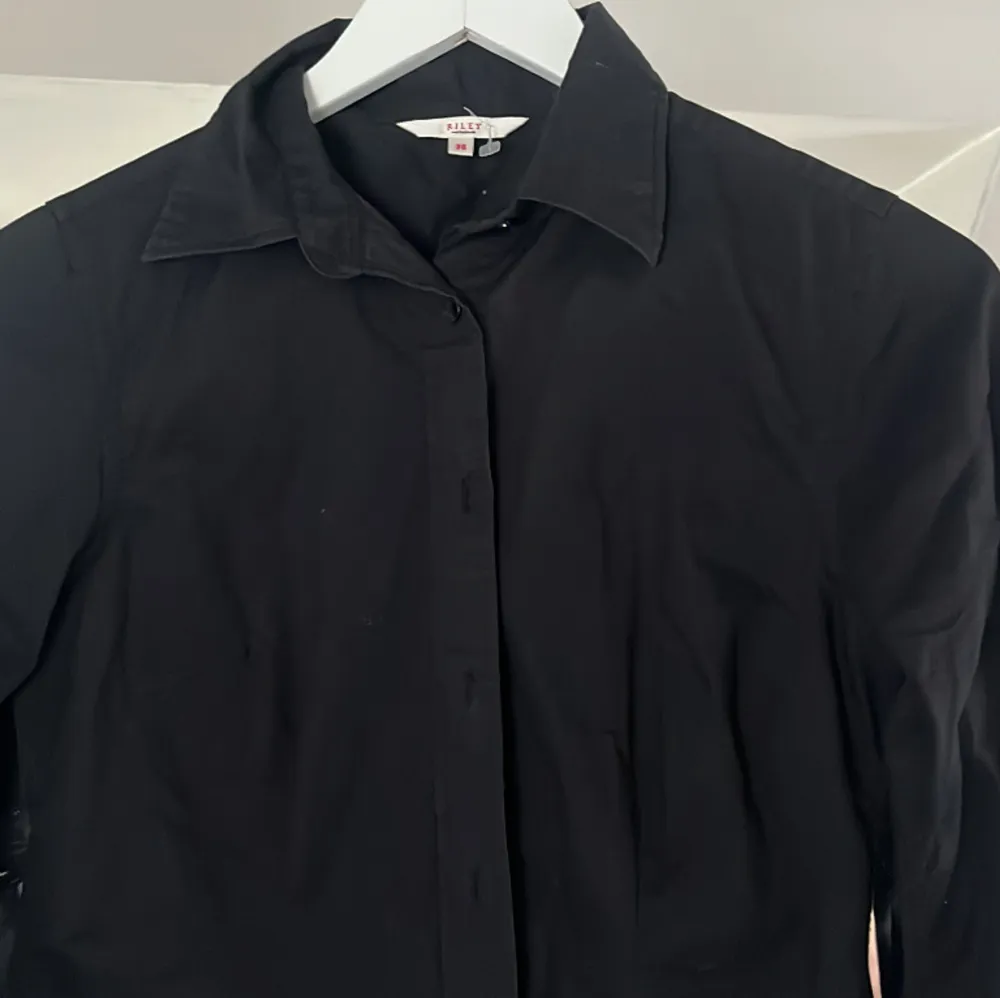 En snygg svart skjorta som ger en fin passform på kroppen. Skjortor.