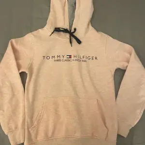 En Tommy Hilfiger hoodie. I en jättefin rosa färg. Har inga skavanker vad jag kan se.