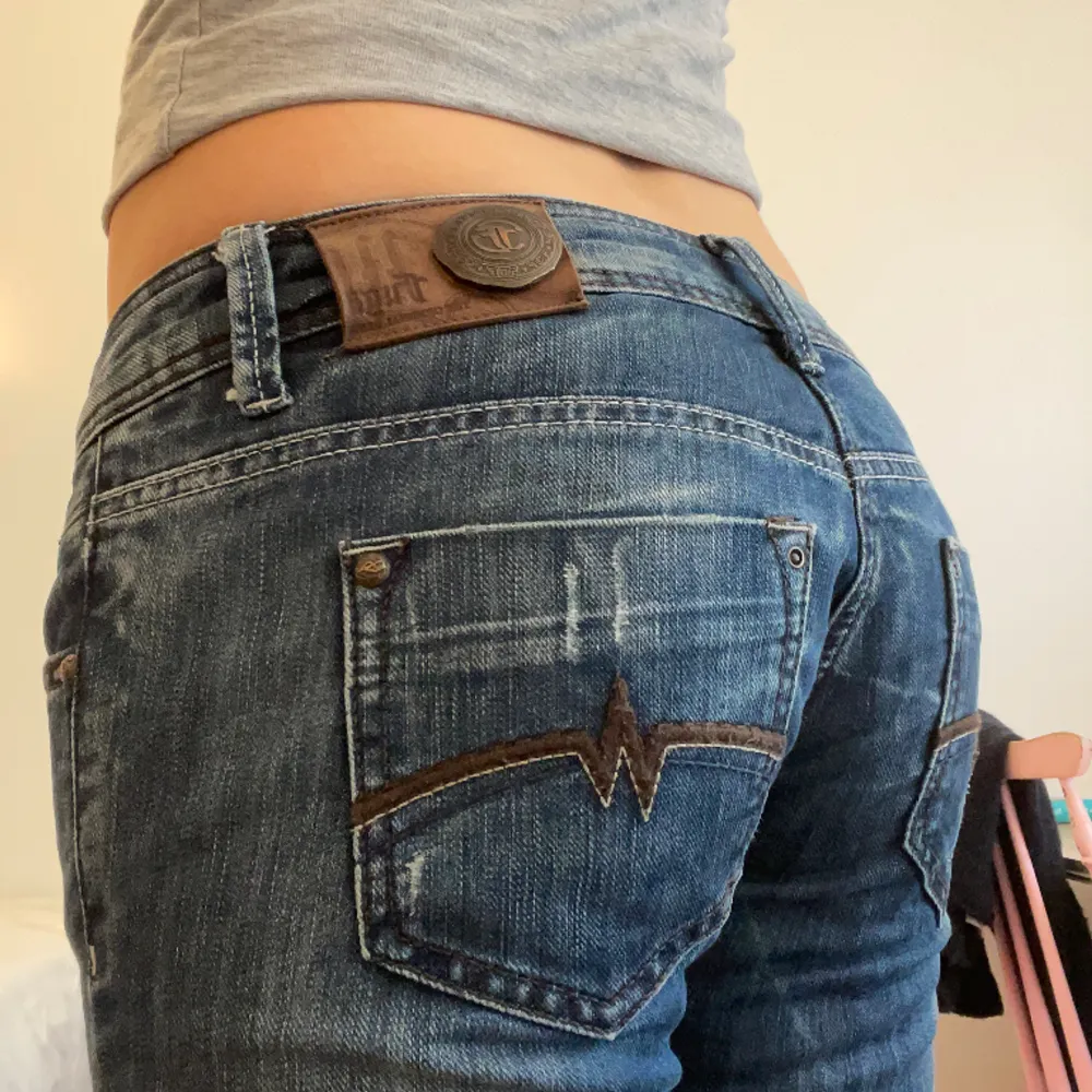 Jättesöta mörkblå lågmidjade jeans köpta secondhand. De är bootcut och har en cool metal-detalj på baksidan och fina bruna detaljer på bakfickorna:) midjemåttet är 40 cm rakt över och innerbenslängden 81 cm. Jag är 170💞. Jeans & Byxor.