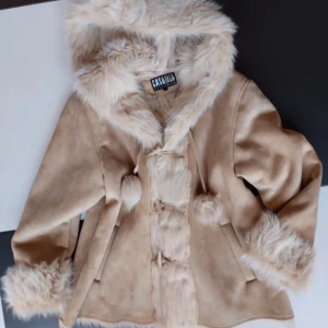 Casamia-pälsjacka - Underbar beige fake-mocka-jacka med furtrim och pälsfoder inuti. Köpt på Vinted, aldrig använd av mig. (Jag är storlek S, därför den ser så stor ut på bilden 😅) Fler bilder, mått etc skickas vid intresse, bara att skriva och fråga :)