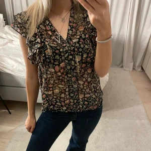 Blus - Fin blommig blus med volang vid axlarna 