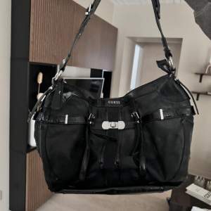 En svarta Guess handväska, köpte för ca 1500kr, lite gammal o sliten där av priset jag säljer den för, skriv om du vill ha mer bilder eller frågor