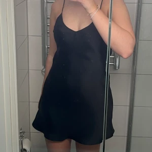 Satin klänning  - Svart mini klänning i satin från Zara, har en liten öppning i ryggen som knyts själv. 