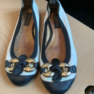 Vit/svarta ballerina - Vit/svarta ballerinaskor med guldig detalj i läder från Novita (scorett) i storlek 38. SUUUPERSKÖNA att gå i. 