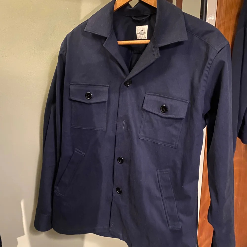 Overshirt från John Henric i topp skick förutom att en knapp har ramlat av, kan skicka med en extra knapp så man kan laga den om man vill.  Skit skönt material och perfekt till svala dagar. Kostymer.