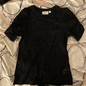 svart spetts t-shirt  - nyinköpt tshirt för 300kr med puffade armar. använd en gång på begravning. 