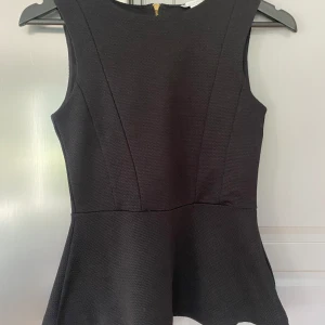Peplum Top strl XS från H&M  - 98% Polyester  2% Elastan  Nyskick  Svart