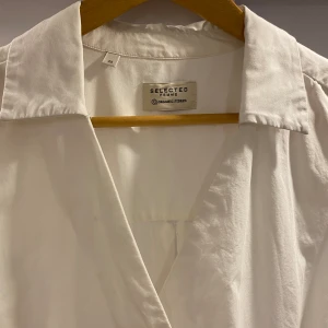 Vit skjorta från Design Only - En jätte fin vit skjorta utan knappar, som istället är syd hela vägen upp som man ser på bilden ovan☺️. Den är köpt för 2 år sedan men enbart använd 1 gång. Älskade den väldigt mycket men passade bara  tyvärr inte min stil🙏🏼