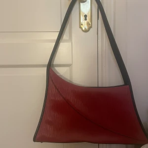 Läderväska Paul Hajn - Cool väska från Paul Hajn. Röd på ena sidan och svart på andra, kan bäras åt båda hållen!