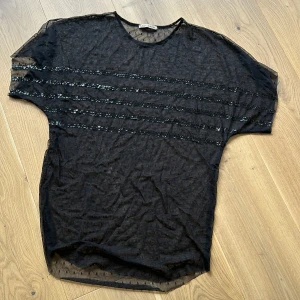 Genomskinlig t-shirt/topp från Rabens Saloner.  - Superfin topp från danska Rabens Saloner. Genomskinlig med paljetter. Nypris 799kr