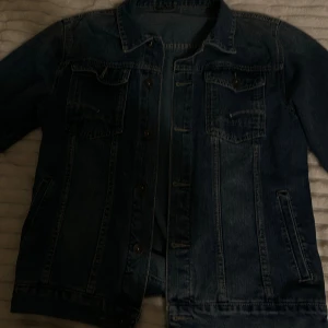 Snygg jeansjacka i klassisk design  - Säljer en snygg jeansjacka i klassisk design. Jackan är i mycket bra skick och har inga synliga skador eller fläckar. Perfekt för både vardagsbruk och för att ge din outfit en cool touch.