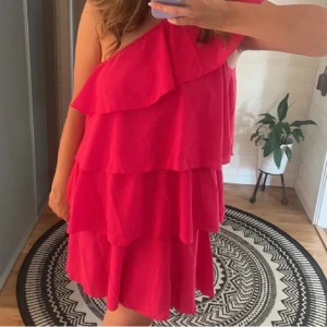 Rosa volang klänning - Säljer den här supersöta rosa klänningen! Det är en one shoulder klänning i volang, väldigt lik zaras gula volang klänning fast denna är i rosa! Är endast använd vid 1 gång därav säljer jag! Köptes på plick. Säljer för 500 + köpare står för frakt ❣️