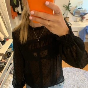 Blus i mesh - Svart mesh blus med lite volanger. Superfin. 