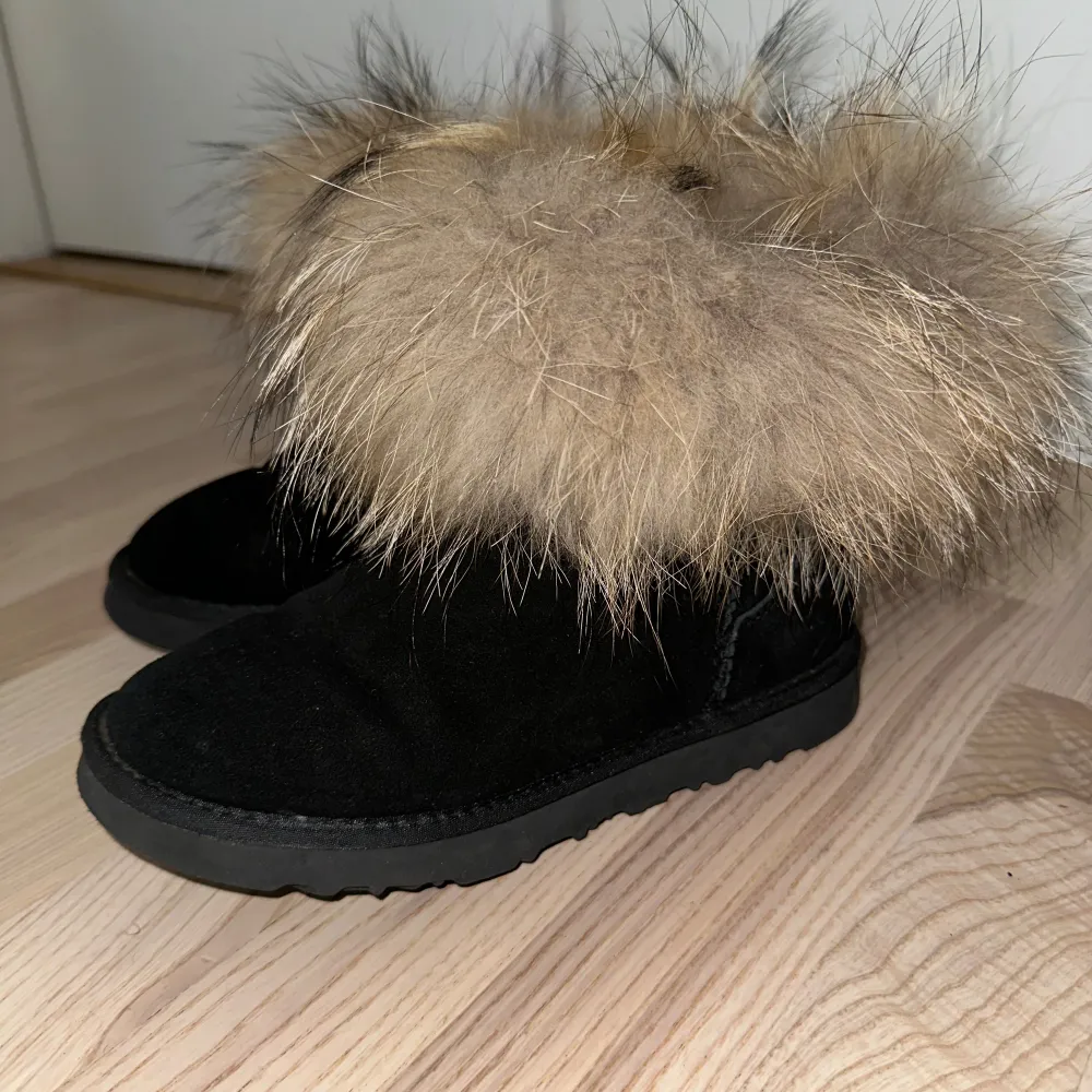 Ett par svarta boots med pälsdetaljer runt skaftet. Skorna har en robust sula och är tillverkade i mocka material. Storlek 38. Nypris 999:-. Skor.