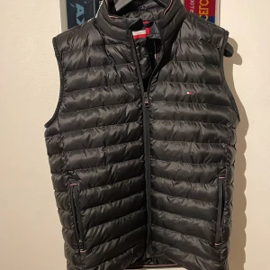 Tommy hilfiger väst - Säljer nu min fräscha Tommy Hilfiger väst i bra skick. Varan är andvänd en sommar. Storleken är M men passar även s och färg svart. 