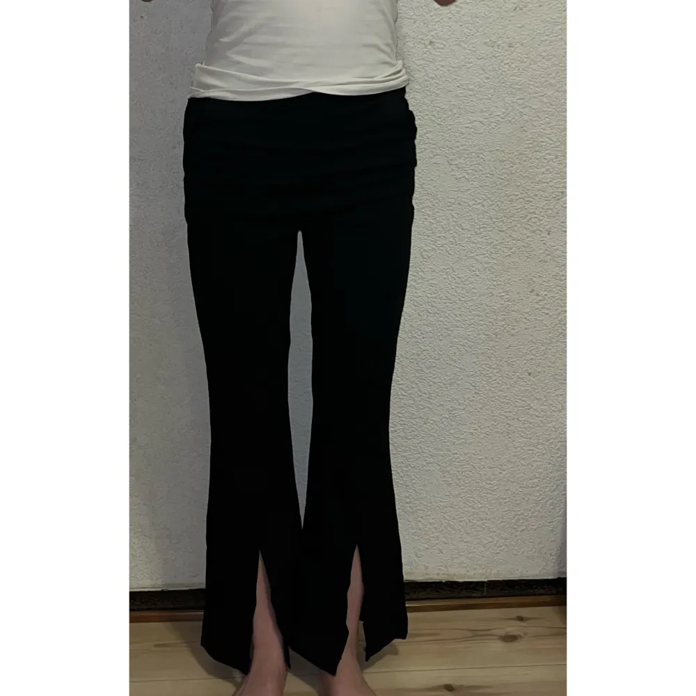 Dessa stilrena svarta byxor har en slits längs ner i mitten och är perfekta för vardagsanvändning. Aldrig använda och i toppskick. Storlek XS (för referens är jag 155 cm lång och väger 43 kg).. Jeans & Byxor.