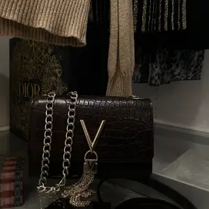 En snygg mörkbrun väska med guld detaljer från Valentino. Väskan är i bra skick och har används fåtal gånger🤎 Ordinarie pris är runt 700kr!