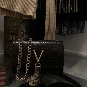 Axelremsväska  - En snygg mörkbrun väska med guld detaljer från Valentino. Väskan är i bra skick och har används fåtal gånger🤎 Ordinarie pris är runt 700kr!