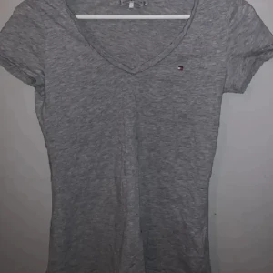 Tommy hilfiger tshirt - Tshirt från tommy hilfiger med v-ringning och små slits på sidorna. Mycket bra skick. Köpt för 400 kr
