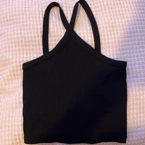 Kors linne från Gina  - Ribbad linne med kors över bröstet, svart och croppat.