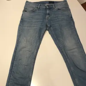 Ljusa jeans från Tiger of Sweden i modellen Evolve. Passformen är skinny/slim i storleken 28/32. Inga slitningar på jeansen