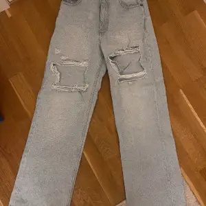 Högmidjade Jeans med vida ben och hål på låren