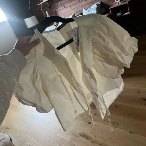 Topp med puffärm gina - Oanvänd topp med puffärm från Gina, säljes då den inte kommer till användning