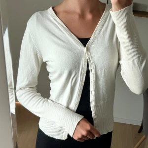 Vit finstickad kofta - Vit finstickad kofta från VILA i stl M, passar även som en S. 🤍 Det är dock en liten fläck på höger framsida, se andra bilden. Den syns inte jättetydligt och kanske går den att få bort.