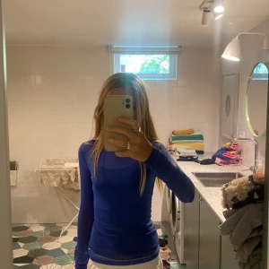 Blå tröja som är små see through  - Fin blå små see through tröja.  Små håll för tummarna. Väldigt bra skick. Passar till många stilar beroende på vad man har till den. Står XXS men passar större (jag har XS/S och den passar mig). Den funkar på fester men passar även till vardags.